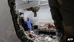 People inspect the damage in a room following Israeli bombardment at Nasser hospital in Khan Yunis in the southern Gaza Strip on Dec. 17, 2023.