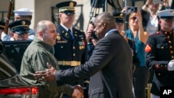 Defense Secretary Lloyd Austin, right, greets Ukraine's Defense Minister Rustem Umerov during an arrival ceremony at the Pentagon, near Washington, July 2, 2024.