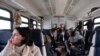 Oksana, 49, who did not want her surname reported, plays a violin inside a commuter train outside Moscow, Russia, Sunday, Feb. 13, 2022.