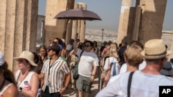 Du khách trong trời nắng nóng ở đồi Acropolis, Athens, Hy Lạp, 13/7/2023 (AP Photo/Petros Giannakouris). 