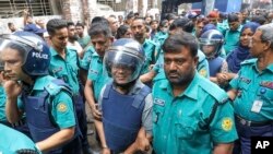 Polisye yo akonpaye Shakil Ahmet, ansyen direkte nouvel Ekattor televizyon (mitan) ak prensipal korespondan li Farzana Rupa (a dwat) nan Dhaka, Bengladesh, 22 Out, 2024. 