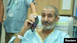 Qaid Farhan Alkadi, a hostage kidnapped in the October 7 Hamas attack, uses his phone as he is reunited with loved ones, at Soroka Medical Center in Beersheba, Israel, Aug. 27, 2024. (Government Press Office/Yossi Ifergan/Handout via Reuters)