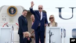 Prezidan Joe Biden, mitan, salye moun sou pis aterisaj la anvan li monte nan avyon prezidansyel la, Air Force One, ak pitit gason ni, Hunter Biden, pitit pitit li, Beau Biden, premye dam Jill Biden ak bel fi li Melissa Cohen, 10 Out, 2022. 