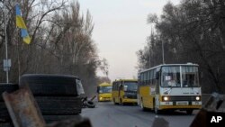 Evacuation buses carrying internally displaced people arrive at an IDP center in Zaporizhzhia, Ukraine, March 25, 2022.