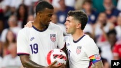 Foto Achiv: Christian Pulisic a dwat remet balon an bay Haji Wright anvan yon chout penalite pandan match amikal seleksyon nasyonal Etazini ak Mawok, Lendi 1 Jyen 2022 nan vil Cincinnati. 