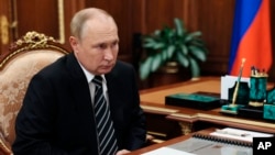 Russian President Vladimir Putin listens to Ivanovo Region Governor Stanislav Voskresensky at Moscow's Kremlin in Moscow, Russia, Oct. 4, 2022. (Kremlin Pool Photo via AP)