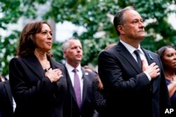 Vis Prezidant Etazini Kamala Harris ak mari li Doug Emhoff kanpe pandan im nasyonal la ap jwe pandan seremoni pou komemore 21e anivese atak teworis 11 Septanm yo, Dimanch 11 Sept. 2022 nan Nouyok.