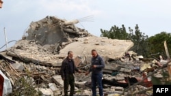 Men check the site of an Israeli air strike that targeted a house in the southern Lebanese village of Jibshit on February 27, 2024.