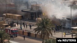 Bomberos iraquíes extinguen un incendio en la entrada de la embajada de Estados Unidos en Bagdad el 1 de enero de 2020.