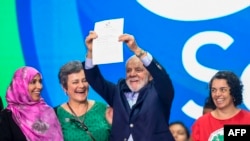 Brazilian President Luiz Inácio Lula da Silva holds a document with the final statement during the closing meeting of the G20 Social Summit in Rio de Janeiro, Brazil, on November 16, 2024. (Photo by Daniel RAMALHO / AFP)