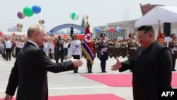 In this pool photograph distributed by the Russian state agency Sputnik, North Korea's leader Kim Jong Un (R) shakes hands with Russian President Vladimir Putin during a welcoming ceremony at Kim Il Sung Square in Pyongyang on June 19, 2024.