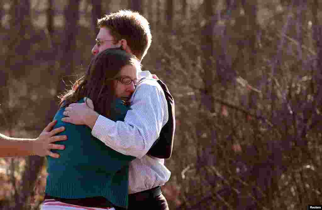 Các phụ huynh an ủi, động viên nhau bên ngoài trường tiểu học Sandy Hook. 