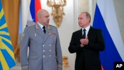 FILE - Russian President Vladimir Putin, right, applauds Col. Gen. Sergei Surovikin during an awards ceremony for troops who fought in Syria, in the Kremlin, in Moscow, Dec. 28, 2017. Putin says Russia's action in Syria has demonstrated the power of the n