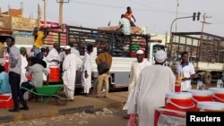 People gather to ride trucks as they flee during clashes between the paramilitary Rapid Support Forces and the army in Khartoum North