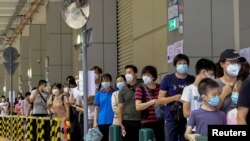 FILE PHOTO: Residents wearing face masks line up to get tested for the coronavirus disease (COVID-19) in Macau, China July 4, 2022.