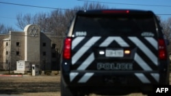 FILE - A police vehicle sits outside of the Congregation Beth Israel Synagogue in Colleyville, Texas, some 25 miles (40 kilometers) west of Dallas, Jan. 16, 2022.