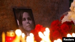 Flowers and candles are placed next to a portrait of Darya Dugina in Moscow