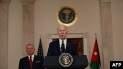 US President Joe Biden speaks to the press as King Abdullah II of Jordan looks on in the Cross Hall of the White House in Washington, DC, on February 12, 2024.