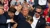 TOPSHOT - Republican candidate Donald Trump is seen with blood on his face surrounded by secret service agents as he is taken off the stage at a campaign event at Butler Farm Show Inc. in Butler, Pennsylvania, July 13, 2024.