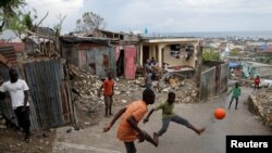 People play soccer on a street next to destroyed houses after Hurricane Matthew hit Jeremie, Haiti.